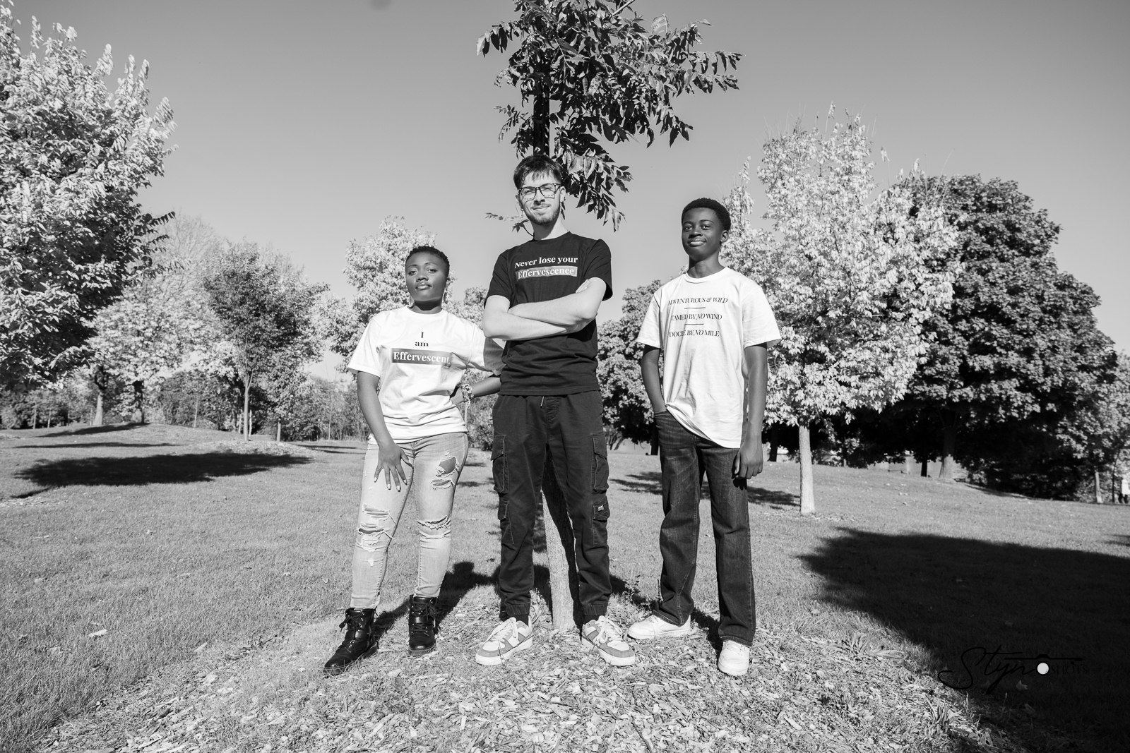 Three models wearing Effervescence tees outdoors, in black and white