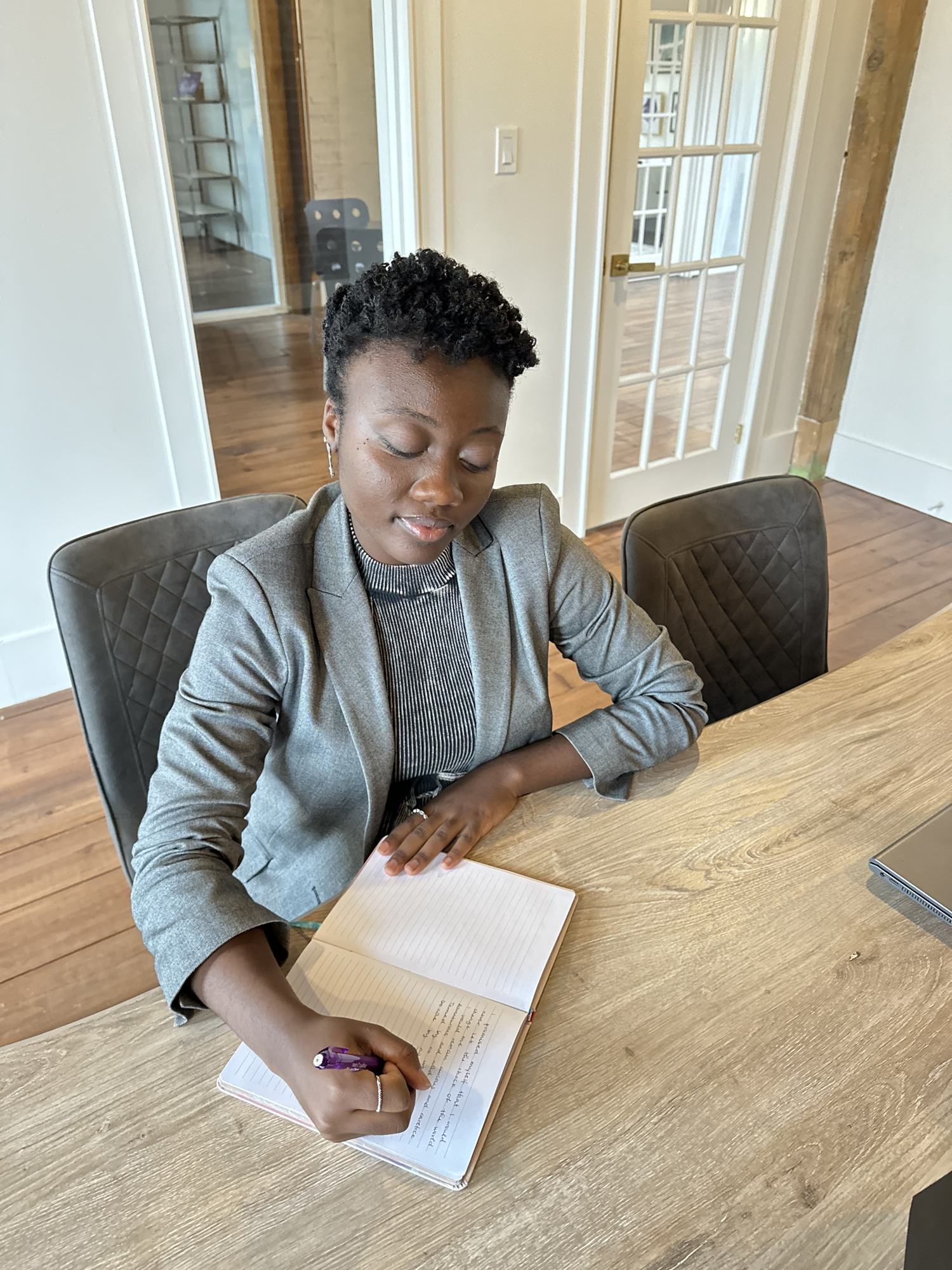 Marie-Paul writing in a notebook at a table